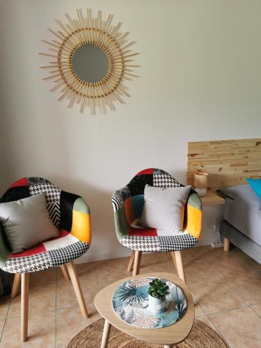 deux chaises et une table dans un salon avec un miroir dans l'établissement Ti'bakoua à Sainte-luce Plage et piscine, à Sainte-Luce