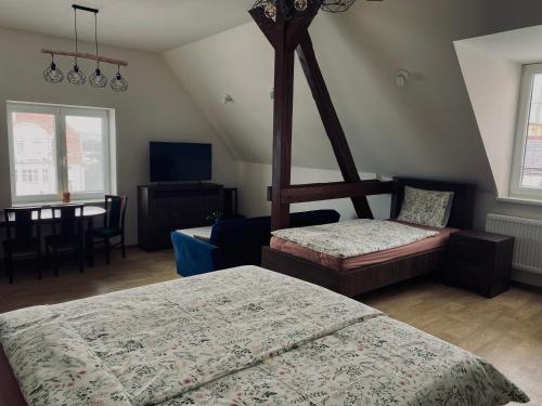 a bedroom with two beds and a chair and a table at Ubytování Stará in Ústí nad Labem
