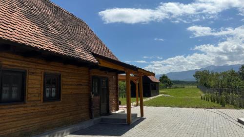 eine Holzhütte mit einem Dach und einer Veranda in der Unterkunft Little Bear Lodge in Sibiu