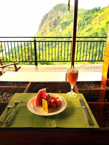 einen Teller mit Essen und einen Drink auf dem Tisch in der Unterkunft The Peak Ella in Ella