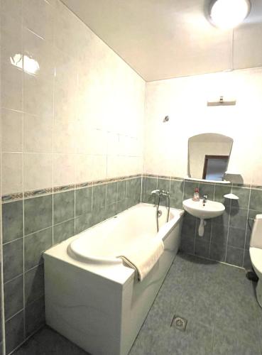 a bathroom with a bath tub and a sink at Sun Shine Apartments in Jūrmala