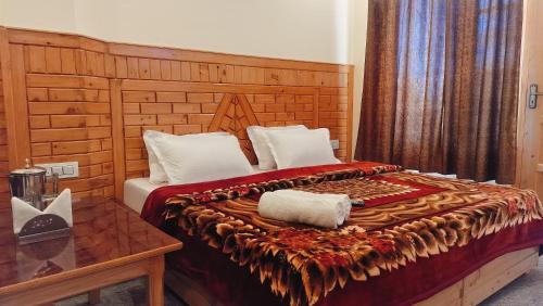 a bedroom with a large bed with a wooden headboard at Kavyansh Forest Valley in Dalhousie