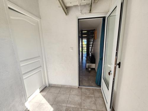 een hal met een open deur en een spiegel bij CASSIOPEE in Saint-Gilles-les-Bains