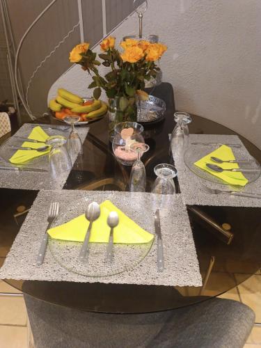 a table with a yellow napkin and utensils on it at Jolie maison de village in Capendu