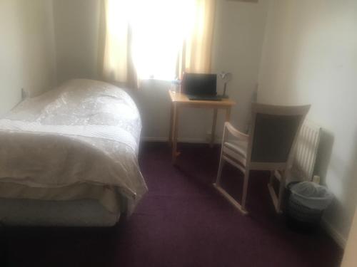 a bedroom with a bed and a desk and a television at 31 Stonelea court in Meanwood