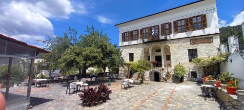 a building with tables and chairs in a courtyard at Archontiko Kantartzi in Portariá