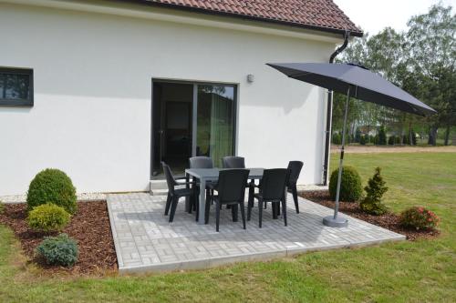 a table and chairs and an umbrella in a yard at Apartmány Benátky in Suchdol nad Lužnicí