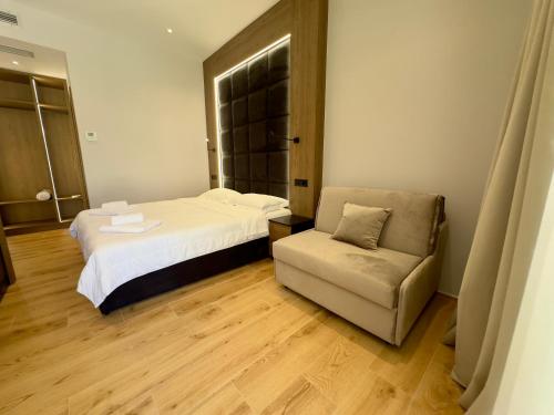 a hotel room with a bed and a chair at ELMAR COMFORT in Vlorë
