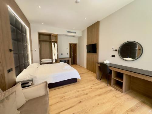 a hotel room with a bed and a desk at ELMAR COMFORT in Vlorë