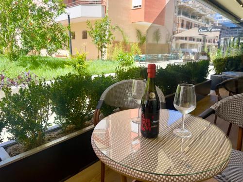 a table with two glasses and a bottle of wine at ELMAR COMFORT in Vlorë