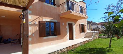 a building with a door and a balcony on it at Summer Villa with sea view,6 min drive from airport, near Seitan Limania beach in Khordhákion