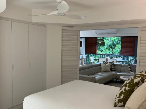a bedroom with a white bed and a couch at Noosa Beach Apartment on HASTING ST French quarter resort.Noosa Heads in Noosa Heads
