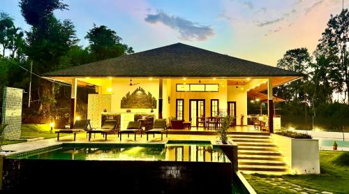 a house with a pool in front of it at Tranquil Resort - Blusalzz Collection, Wayanad - Kerala in Ambalavayal