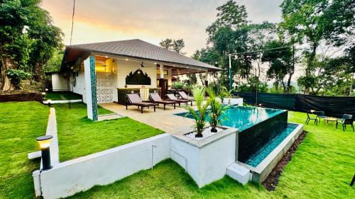 a backyard with a swimming pool and a house at Tranquil Resort - Blusalzz Collection, Wayanad - Kerala in Ambalavayal