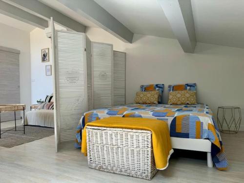 una camera da letto con un letto con una coperta gialla sopra di Nid douillet vue mer Hyères a Hyères