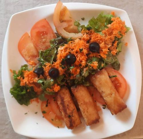 a plate of food with a salad and vegetables at Hôtel La Belle Etoile & SPA in Saly Portudal