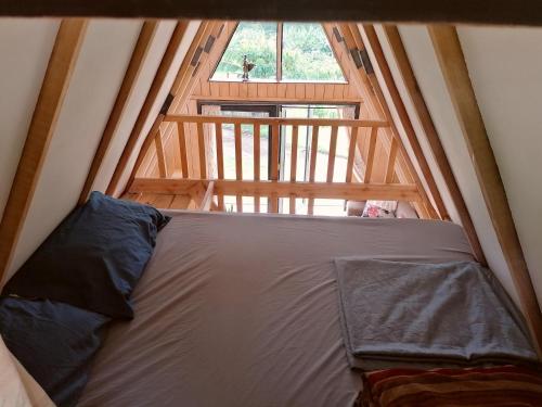 a bed in a room with a large window at JP's A frame cabin in Fort Portal