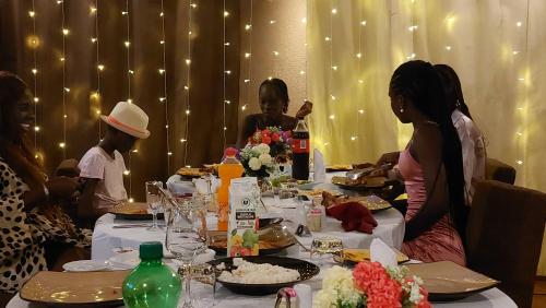 a group of people sitting around a table with food at Hôtel La Belle Etoile & SPA in Saly Portudal