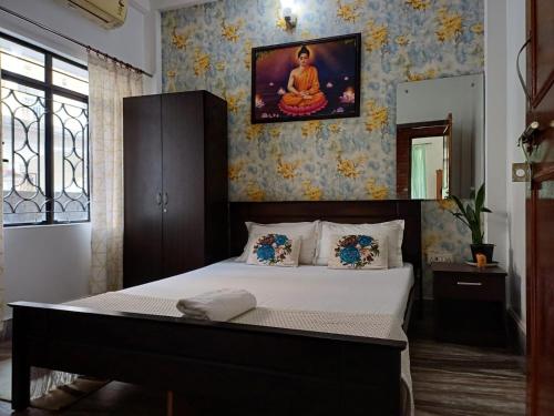 sypialnia z łóżkiem z obrazem na ścianie w obiekcie Lasaya apartment w mieście Siliguri