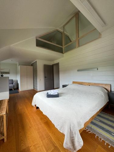 a bedroom with a large white bed in a room at Karkle SummerHOUSE, sea view villa in Karklė