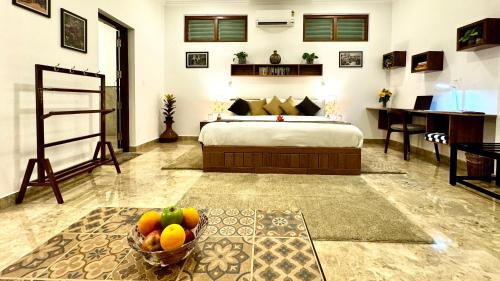 a bedroom with a bed and a bowl of fruit at Tranquil Resort - Blusalzz Collection, Wayanad - Kerala in Ambalavayal