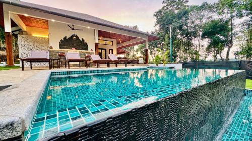 a swimming pool in the backyard of a house at Tranquil Resort - Blusalzz Collection, Wayanad - Kerala in Ambalavayal