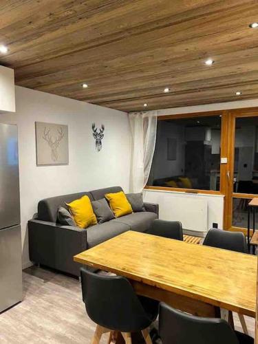 un salon avec un canapé et une table en bois dans l'établissement Le Pierrer 5 4 couchages, à Valmorel