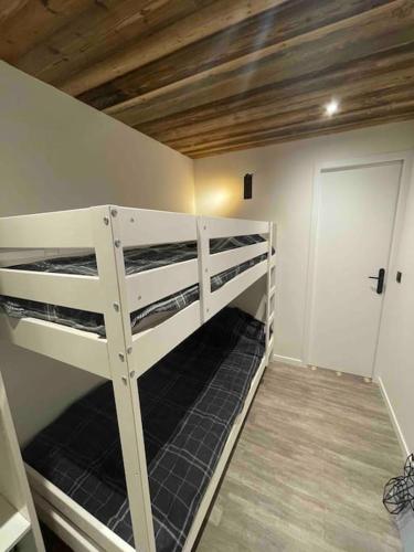 une chambre avec deux lits superposés dans une pièce dans l'établissement Le Pierrer 5 4 couchages, à Valmorel