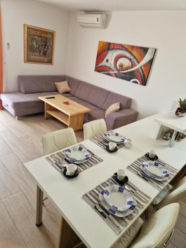 sala de estar con mesa y sofá en Apartments Šarić, en Baška Voda