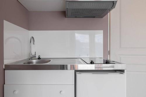a kitchen with a stainless steel sink and a stove at Les Lilas in Podensac