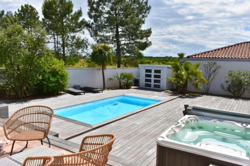 une terrasse avec une piscine, des chaises et un bain à remous dans l'établissement Éden Basque - Piscine-SPA-Plage, à Anglet
