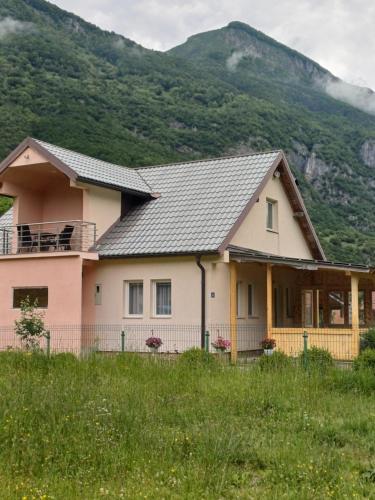 a house with a mountain in the background at Breti's GuestHouse in Vusanje