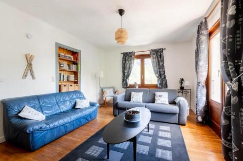 a living room with a blue couch and a table at Spacieux T3 Parking FREE WIFI Haut-Débit in Magland