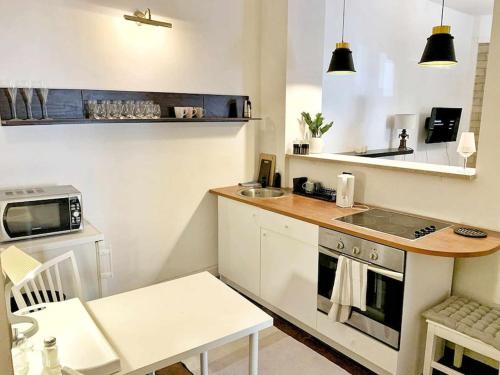 una piccola cucina con lavello e fornello di Wygodny apartament Piotrkowska a Łódź