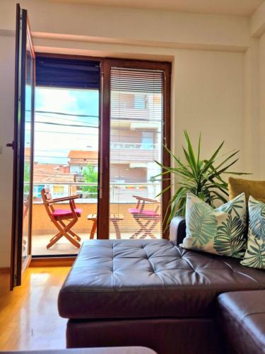 a living room with a couch and a view of a patio at Amsterdam Apartment Strumica in Strumica