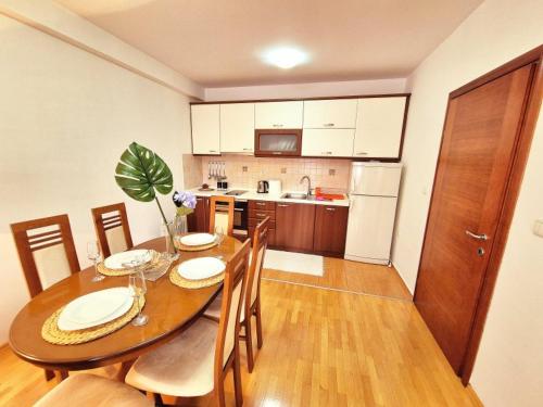 a kitchen with a wooden table with chairs and a dining room at Amsterdam Apartment Strumica in Strumica