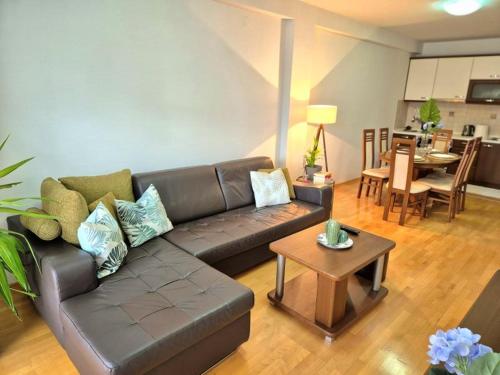a living room with a leather couch and a table at Amsterdam Apartment Strumica in Strumica