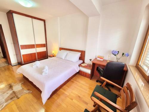 a bedroom with a bed and a desk and a chair at Amsterdam Apartment Strumica in Strumica