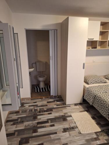 a room with a bedroom with a bed and a toilet at Makol in Primošten