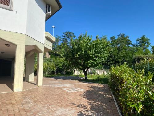 a brick walkway next to a building with a tree at Casa Isa in Narni Scalo