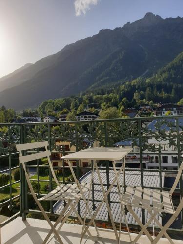 d'une table et de deux chaises sur un balcon avec vue sur la montagne. dans l'établissement Majestic T2 calme, spacieux, central, avec parking, à Chamonix-Mont-Blanc