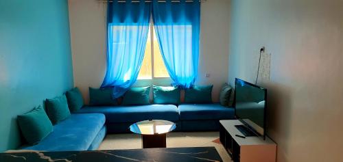 a living room with a blue couch and a window at Vivre un experience inoubliable in Casablanca