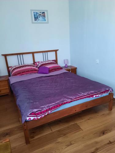 een bed in een slaapkamer met een paars dekbed bij Władysławowo Łebcz Modrzewiowa in Łebcz