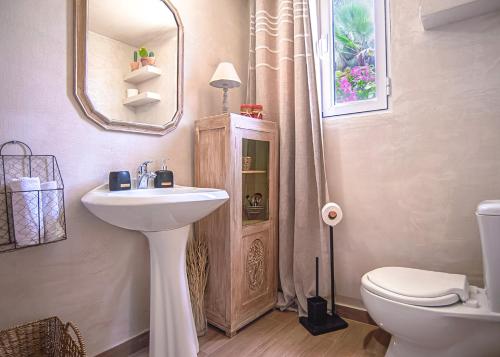 a bathroom with a sink and a toilet and a mirror at PRETTY SPITI Holiday Home in Laganas
