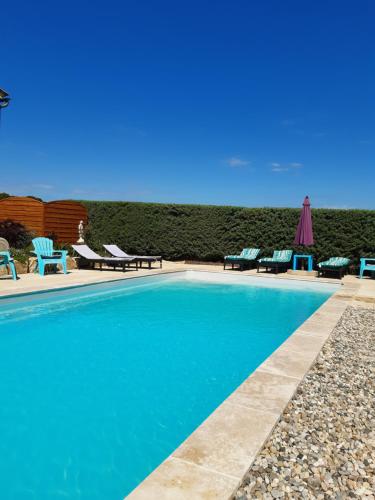 une piscine avec chaises longues et transats à côté d'une plage dans l'établissement gîte neuf 