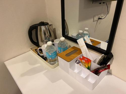 a counter with bottles of water and a mirror at Jb Sojourn in Skudai