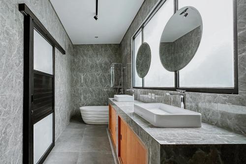 een badkamer met twee wastafels en een spiegel bij Semat Raya Village in Canggu