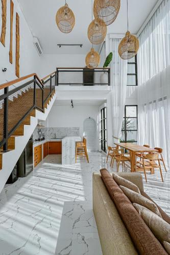 a living room with a staircase and a table at Semat Raya Village in Canggu