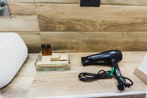 - un sèche-cheveux noir sur un comptoir à côté d'un lavabo dans l'établissement Catania House, à Catane