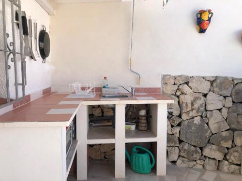 - une cuisine avec une table et un mur en pierre dans l'établissement Casita Mona - Attractive Studio Apartment 4kms from the beach, à Moraira
